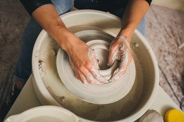 Hands working on pottery wheel