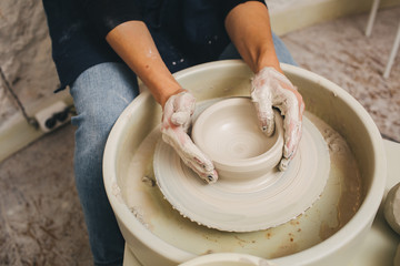 Hands working on pottery wheel