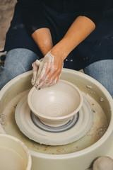 Hands working on pottery wheel