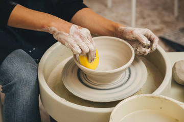 Hands working on pottery wheel