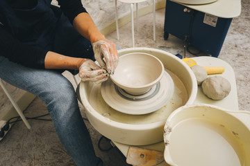 Hands working on pottery wheel