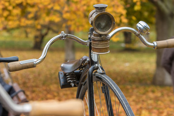 Fototapeta na wymiar Vintage penny-farthing bicycle, colorful autumn yellow leaves in background