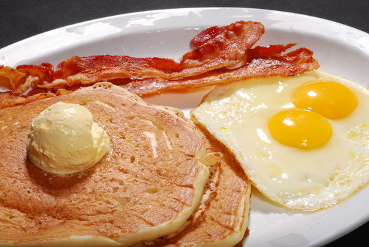 Pancakes With Butter, Eggs And Bacon