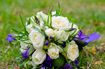 Wedding bouquet of white roses and purple irises.