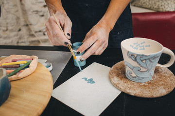 Obraz na płótnie Canvas Female hands working on mug