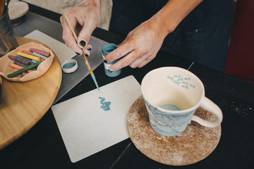 Fototapeta na wymiar Female hands working on mug