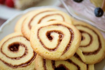 Close up of spiral cookies laid on white plate.