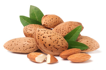 heap of almonds in their skins and peeled with leaf isolated on white background