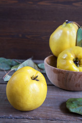 The fresh quince fruit on dark wooden table. An autumn still life.