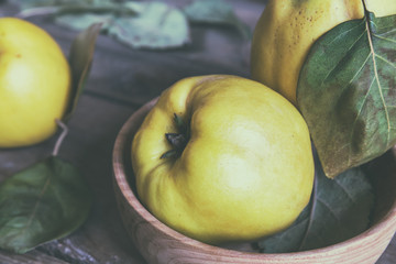 The fresh quince fruit on dark wooden table. An autumn still life. Coloring and processing photo