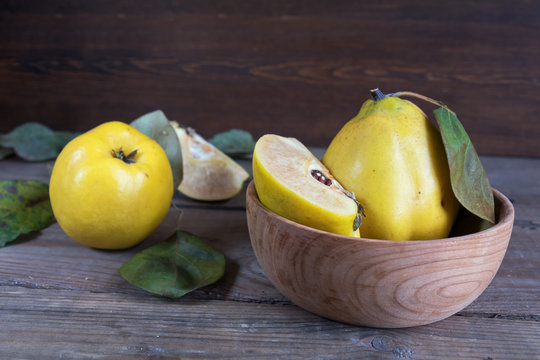 The fresh quince fruit on dark wooden table. An autumn still life.