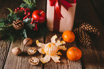 Tangerins on a brown wooden table. Christmas gift with red ribbon. Christmas composition. Christmas concept. Winter holidays concept. Winter holidays.
