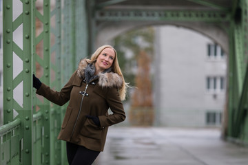 Fototapeta premium Attractive blonde woman wearing winter jacket on street