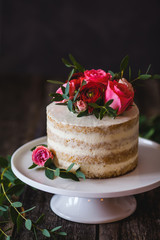 Appetizing wedding cake with flowers in rustic style on dark background - 127233287