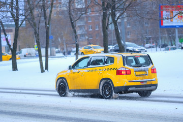 Moscow, Russia - November, 12, 2016: Taxi on a snow-covered road after high snow-storm in Moscow, Russia