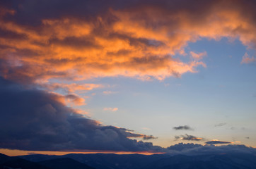 Clouds, illuminated from below by the setting sun in the mountains.