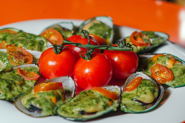 Mussels on a plate with cherry tomatoes.