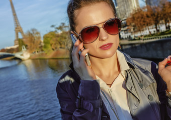 young trendy woman talking on cell phone near Eiffel tower