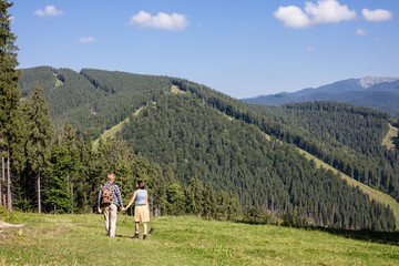 Fototapeta na wymiar Young couple of travelers enjoying mountain view