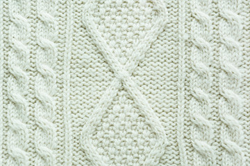 Texture of knitted handmade. Christmas white sweater close up. Wallpaper or abstract background.