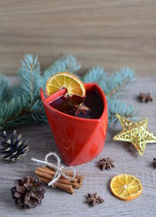 Cup of hot wine with christmas decorations on wooden table 