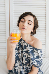 Girl drinking orange juice at Breakfast in bed