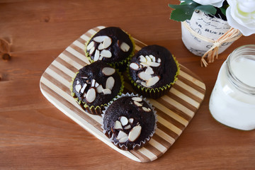 chocolate cup cakes with crispy sliced almonds on top and milk 