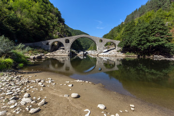 Fototapeta na wymiar Amazing Reflection of The Devil's Bridge in Arda river and Rhodopes mountain, Kardzhali Region, Bulgaria