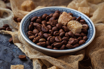 Bowl of coffee beans and brown cane sugar