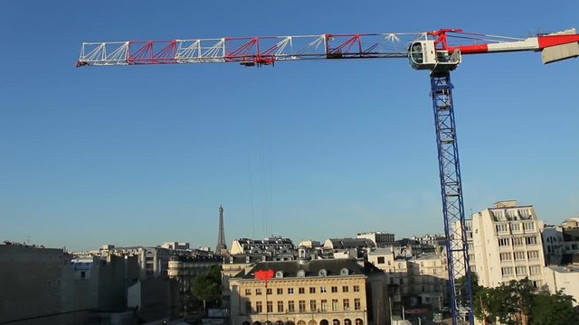 Construction Cranes On A Large Construction Site In Paris With Eiffel Tower In The Background