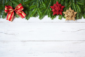 Christmas wooden background with fir branches, star and red ribbon