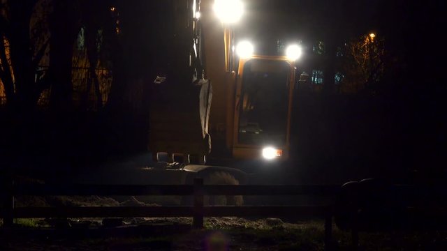 Tractor rides on construction site at night