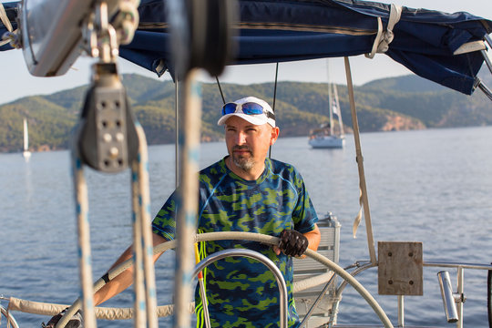 Skipper at the helm of his sailing yacht.