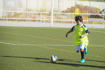 Niño en un entrenamiento de fútbol 7, deportes de equipo para actividades extraescolares