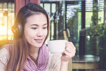 A woman drinking coffee and listening to music in the morning.