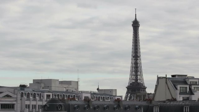 The iconic Eiffel Tower filmed in time lapse with clouds passing by and dusk setting in. Filmed with smooth zoom in.
