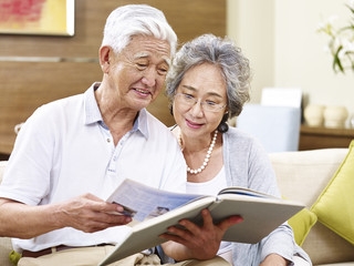 senior asian couple reading a book together