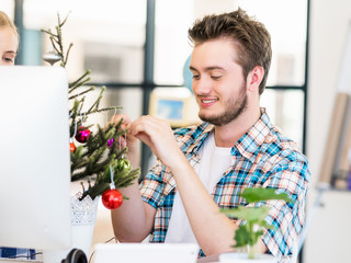 Portrait of smiling office worker with little Christmas tree