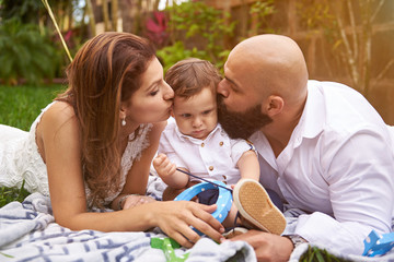 Parents kissing his son