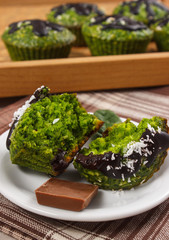 Fresh muffins with spinach, desiccated coconut and chocolate glaze, delicious healthy dessert