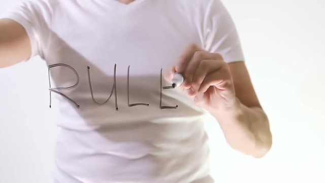 businessman rules writes marker on a transparent board