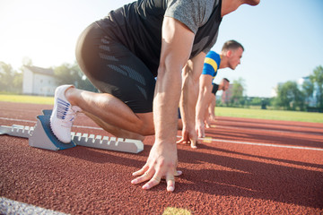 Runners preparing for race at starting blocks