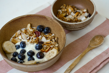 brunch : home made yogurt with granola and banana in wooden bowl.