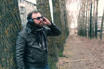 beard man in park with headphon