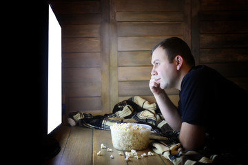 Fototapeta premium young man watching television at home on the floor