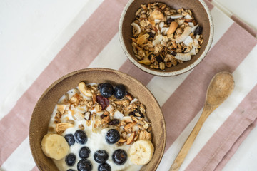 brunch : home made yogurt with granola and banana in wooden bowl.