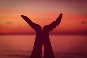 exercise and serenity - woman hands at sunset beach