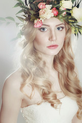 girl with a wreath of flowers on her head on gray background