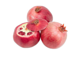 Two whole pomegranates and one cut pomegranate on light background