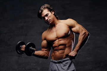 Shirtless abdominal male hold dumbbell.